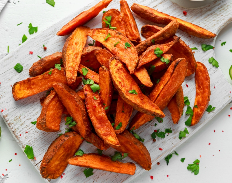 Healthy Homemade Baked Orange Sweet Potato wedges with fresh cream dip sauce, herbs, salt and pepper